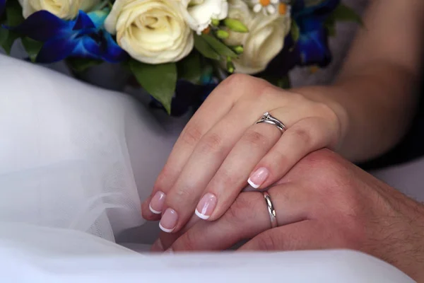 Mano dello sposo e la sposa con fedi nuziali — Foto Stock