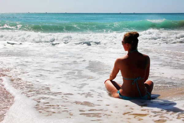 Das Mädchen meditiert am Ufer des Ozeans. — Stockfoto
