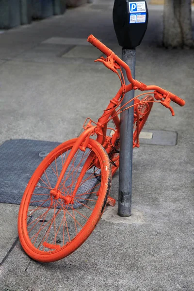 Geparkeerde oranje fiets — Stockfoto