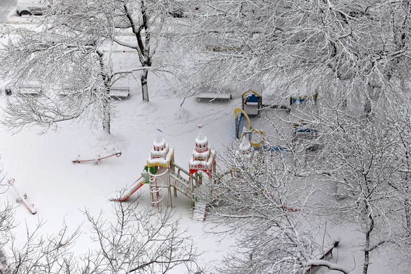Пустынная детская площадка, покрытая снегом — стоковое фото