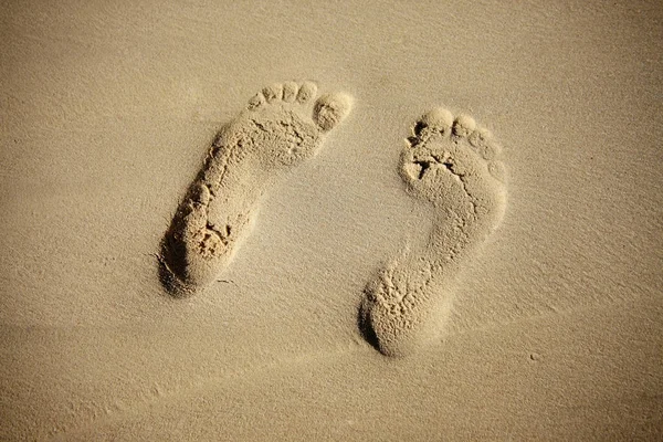 Paar afdrukken van vrouwelijke benen op zand — Stockfoto