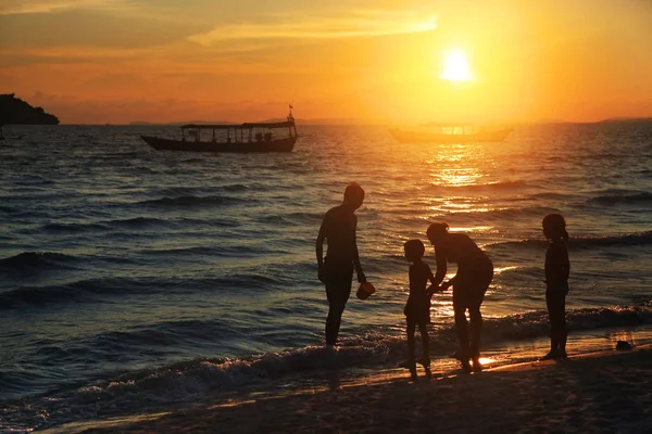 日落时一家人在海滩上 — 图库照片