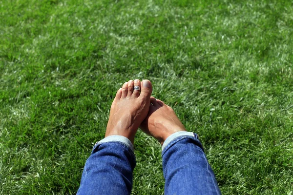 Pies desnudos en hierba verde, mujer relajándose en la naturaleza — Foto de Stock