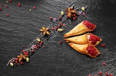 Siyah taş bir tabakta baharatlarla süslenmiş gevrek boynuzlu tavşan ezmesi.