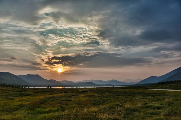 Gölün ve dağların üzerinde güzel bir gün batımı