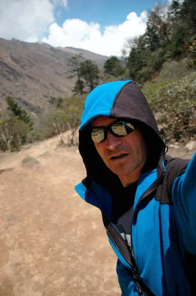 Man in a hood against the background of the Nepal mountains — Stock Photo, Image