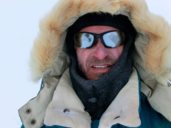 Kış giysileri ve beyaz bir arka plan üzerinde güneş gözlüğü dağcı