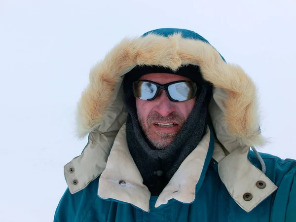 Kış giysileri ve beyaz bir arka plan üzerinde güneş gözlüğü dağcı