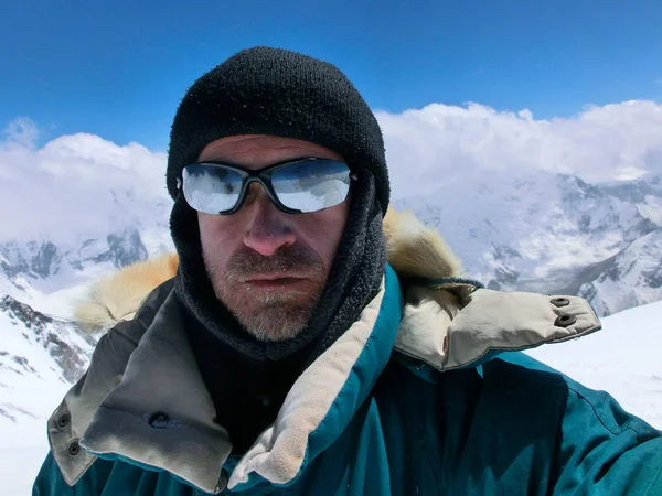 Dağcı kış giysileri ve arka planı dağ güneş gözlüğü