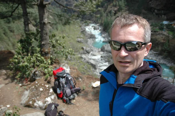 Bir uzun yürüyüşe çıkan kimse bir dağ nehir Nepal arka plan üzerinde portresi