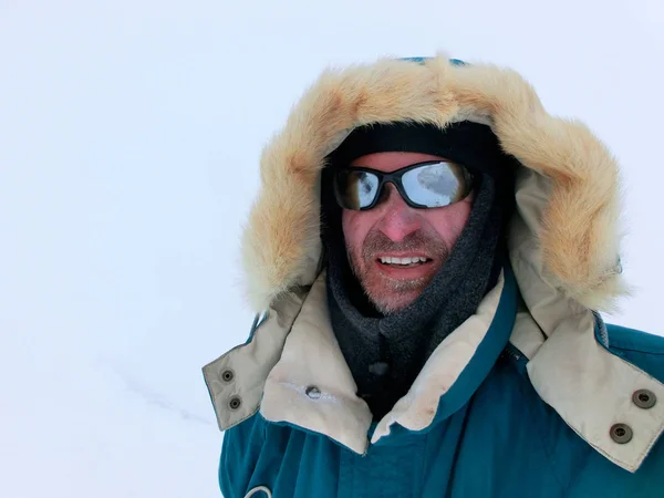 Montañista en ropa de invierno y gafas de sol sobre un fondo blanco —  Fotos de Stock