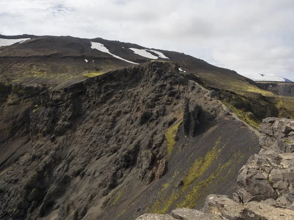 O caminho ao longo da crista preta de um vulcão, coberto com musgo verde brilhante, Islândia — Fotografia de Stock