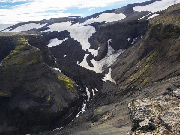 Slopes of the volcano Eyjafjallajokull with black lava fields and snow caps — Stock Photo, Image
