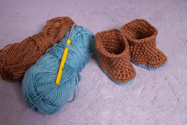 Knitted boots. Knitted shoes. Booties for babies. Made by hands. — Stock Photo, Image