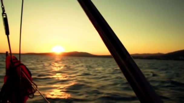 Puesta de sol desde una tabla de yates - la vela y los detalles del yate en el mar — Vídeo de stock