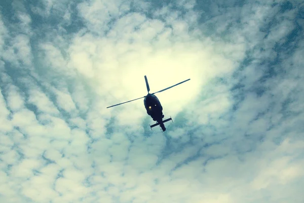 Mavi gökyüzünde uçan helikopter.