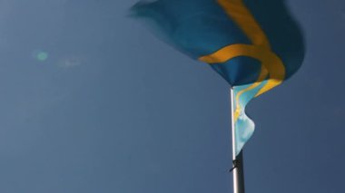 İsveç bayrağı sallayarak karşı mavi gökyüzü
