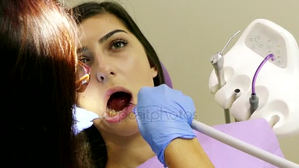 Dentiste au travail en unité dentaire avec une jeune patiente — Video