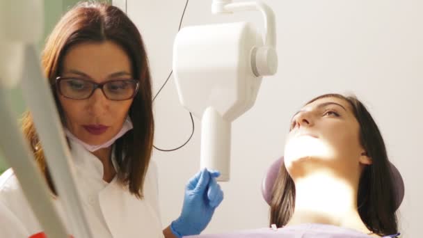 Dentysta w pracy w unit stomatologiczny z pacjentem młodej kobiety — Wideo stockowe