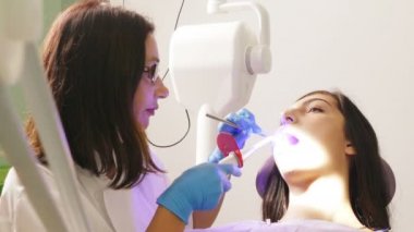 Dişçi diş ünitesi bir genç kadın hasta ile çalışmak