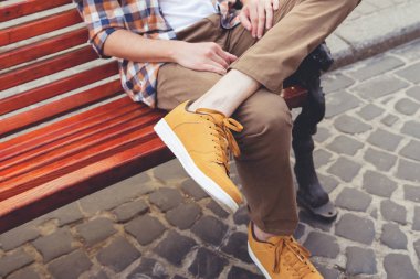 Bir adam şehirde kırmızı bankta oturuyor