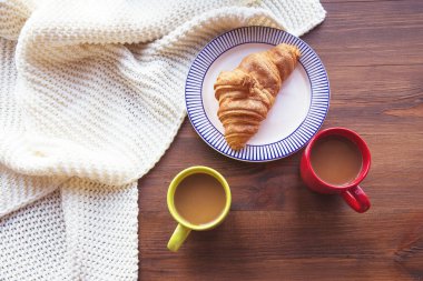 İki bardak sütlü kahve ve bir plaka ile kruvasan Fransız