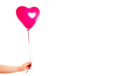 Kadın eli pembe kauçuk, şişme kalp şeklinde balon tutuyor. Aşk, ilişki, sevgililer günü ve doğum günü kutlaması konsepti. Stüdyo görüntüsü boş kopya alanı olan bulanık bir arkaplan üzerinde