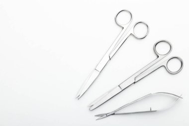 Çelik cerrahi aletler ve laboratuvar ekipmanları beyaz arka planda izole edilmiş. Profesyonel klinik aletleri. Tıbbi, cerrahi, ambulans ve veteriner konsepti. Yumuşak seçici odaklı yakın plan