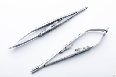 Çelik cerrahi aletler ve laboratuvar ekipmanları beyaz arka planda izole edilmiş. Profesyonel klinik aletleri. Tıbbi, cerrahi, ambulans ve veteriner konsepti. Yumuşak seçici odaklı yakın plan