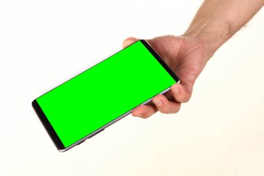 İnsan eli, avucunda boş bir krom ekran olan modern bir akıllı telefonu tutar. Teknoloji ve reklam kavramı. Ayrıntılı yakın çekim stüdyo çekimi soyut beyaz arka planda izole