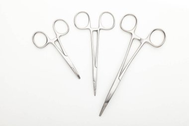 Çelik cerrahi aletler ve laboratuvar ekipmanları beyaz arka planda izole edilmiş. Profesyonel klinik aletleri. Tıbbi, cerrahi, ambulans ve veteriner konsepti. Yumuşak seçici odaklı yakın plan