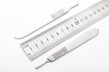 Çelik cerrahi aletler ve laboratuvar ekipmanları beyaz arka planda izole edilmiş. Profesyonel klinik aletleri. Tıbbi, cerrahi, ambulans ve veteriner konsepti. Yumuşak seçici odaklı yakın plan