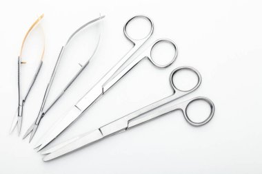 Çelik cerrahi aletler ve laboratuvar ekipmanları beyaz arka planda izole edilmiş. Profesyonel klinik aletleri. Tıbbi, cerrahi, ambulans ve veteriner konsepti. Yumuşak seçici odaklı yakın plan