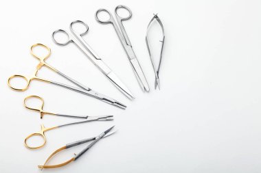 Çelik cerrahi aletler ve laboratuvar ekipmanları beyaz arka planda izole edilmiş. Profesyonel klinik aletleri. Tıbbi, cerrahi, ambulans ve veteriner konsepti. Yumuşak seçici odaklı yakın plan