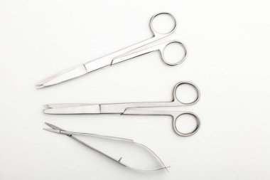 Çelik cerrahi aletler ve laboratuvar ekipmanları beyaz arka planda izole edilmiş. Profesyonel klinik aletleri. Tıbbi, cerrahi, ambulans ve veteriner konsepti. Yumuşak seçici odaklı yakın plan