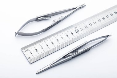 Çelik cerrahi aletler ve laboratuvar ekipmanları beyaz arka planda izole edilmiş. Profesyonel klinik aletleri. Tıbbi, cerrahi, ambulans ve veteriner konsepti. Yumuşak seçici odaklı yakın plan