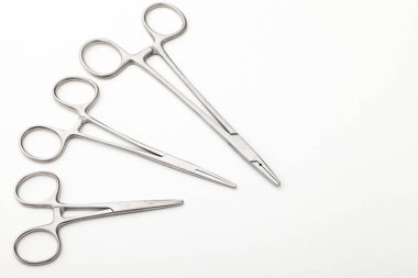 Çelik cerrahi aletler ve laboratuvar ekipmanları beyaz arka planda izole edilmiş. Profesyonel klinik aletleri. Tıbbi, cerrahi, ambulans ve veteriner konsepti. Yumuşak seçici odaklı yakın plan