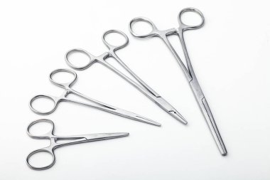 Çelik cerrahi aletler ve laboratuvar ekipmanları beyaz arka planda izole edilmiş. Profesyonel klinik aletleri. Tıbbi, cerrahi, ambulans ve veteriner konsepti. Yumuşak seçici odaklı yakın plan