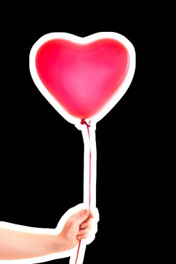 Kadın eli kırmızı kauçuk, şişme kalp şeklinde balon tutuyor. Aşk, ilişki, sevgililer günü ve doğum günü kutlaması konsepti. Boş kopya alanı olan dergi tarzı moda kolajı