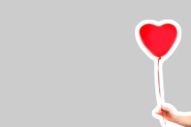 Kadın eli kırmızı kauçuk, şişme kalp şeklinde balon tutuyor. Aşk, ilişki, sevgililer günü ve doğum günü kutlaması konsepti. Boş kopya alanı olan dergi tarzı moda kolajı