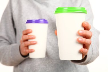 İnsan eli plastik kapaklı boş bir kahve fincanı tutar. Tek kullanımlık fincana çay ya da kahve konsepti. Metin veya logo için yeri ve yeri kopyala. Beyaz bir arkaplanda izole edilmiş