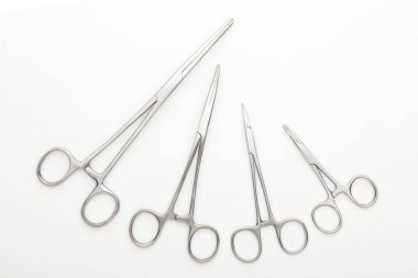 Çelik cerrahi aletler ve laboratuvar ekipmanları beyaz arka planda izole edilmiş. Profesyonel klinik aletleri. Tıbbi, cerrahi, ambulans ve veteriner konsepti. Yumuşak seçici odaklı yakın plan