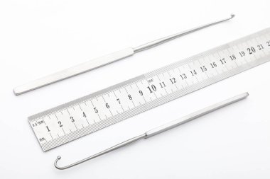 Çelik cerrahi aletler ve laboratuvar ekipmanları beyaz arka planda izole edilmiş. Profesyonel klinik aletleri. Tıbbi, cerrahi, ambulans ve veteriner konsepti. Yumuşak seçici odaklı yakın plan