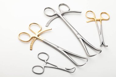 Çelik cerrahi aletler ve laboratuvar ekipmanları beyaz arka planda izole edilmiş. Profesyonel klinik aletleri. Tıbbi, cerrahi, ambulans ve veteriner konsepti. Yumuşak seçici odaklı yakın plan