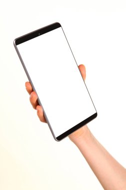 İnsan eli, avucunda boş bir krom ekran olan modern bir akıllı telefonu tutar. Teknoloji ve reklam kavramı. Ayrıntılı yakın çekim stüdyo çekimi soyut beyaz arka planda izole