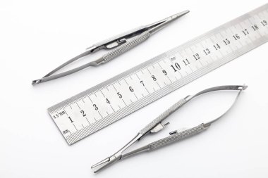 Çelik cerrahi aletler ve laboratuvar ekipmanları beyaz arka planda izole edilmiş. Profesyonel klinik aletleri. Tıbbi, cerrahi, ambulans ve veteriner konsepti. Yumuşak seçici odaklı yakın plan