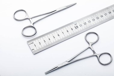 Çelik cerrahi aletler ve laboratuvar ekipmanları beyaz arka planda izole edilmiş. Profesyonel klinik aletleri. Tıbbi, cerrahi, ambulans ve veteriner konsepti. Yumuşak seçici odaklı yakın plan