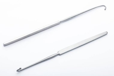 Çelik cerrahi aletler ve laboratuvar ekipmanları beyaz arka planda izole edilmiş. Profesyonel klinik aletleri. Tıbbi, cerrahi, ambulans ve veteriner konsepti. Yumuşak seçici odaklı yakın plan