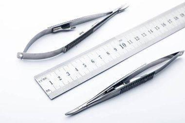 Çelik cerrahi aletler ve laboratuvar ekipmanları beyaz arka planda izole edilmiş. Profesyonel klinik aletleri. Tıbbi, cerrahi, ambulans ve veteriner konsepti. Yumuşak seçici odaklı yakın plan