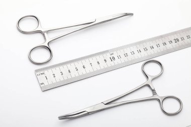 Çelik cerrahi aletler ve laboratuvar ekipmanları beyaz arka planda izole edilmiş. Profesyonel klinik aletleri. Tıbbi, cerrahi, ambulans ve veteriner konsepti. Yumuşak seçici odaklı yakın plan